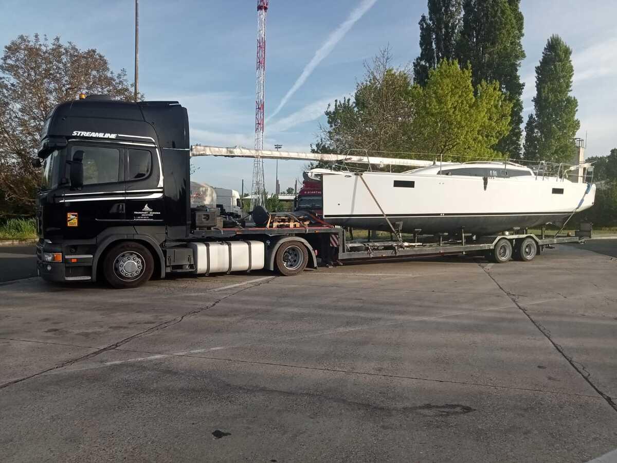 Samochód transportowy przewożący łódź żaglową