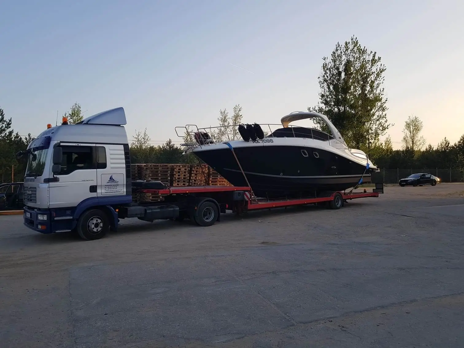 Łódź motorowa transportowana na naczepie w porcie